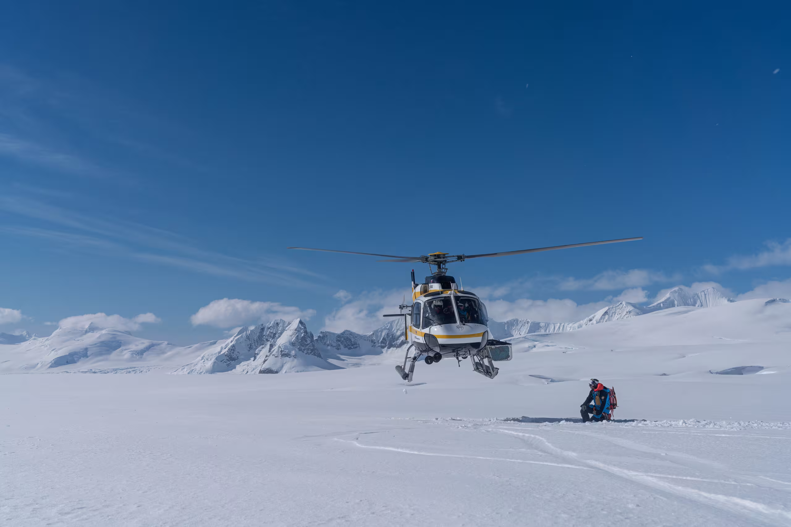 Helicopter landing on snow with blue sky