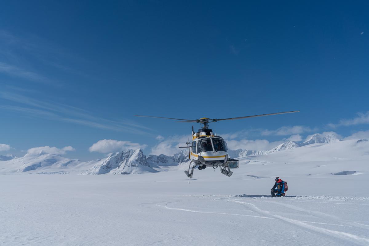 Helicopter landing on snow with blue sky