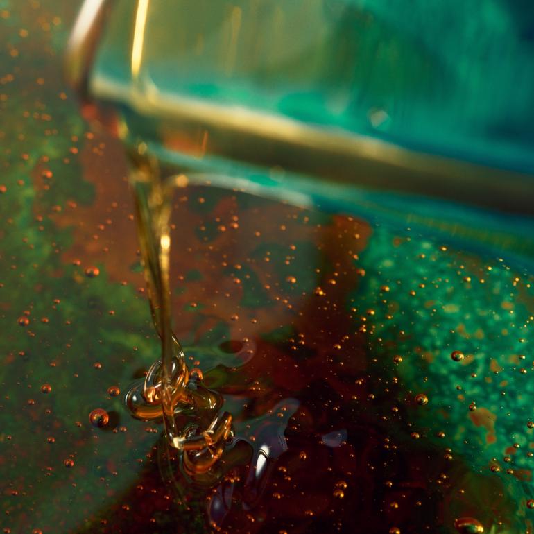 Caramel pouring into orange oil.